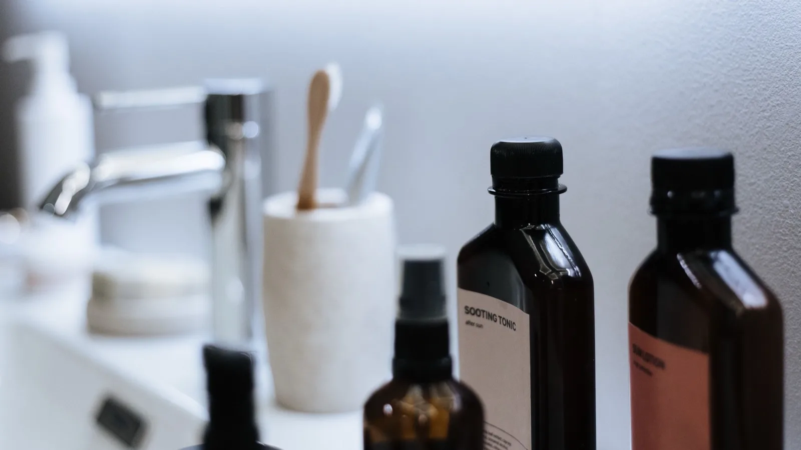 Skincare products organized on a bathroom sink for a simple routine.