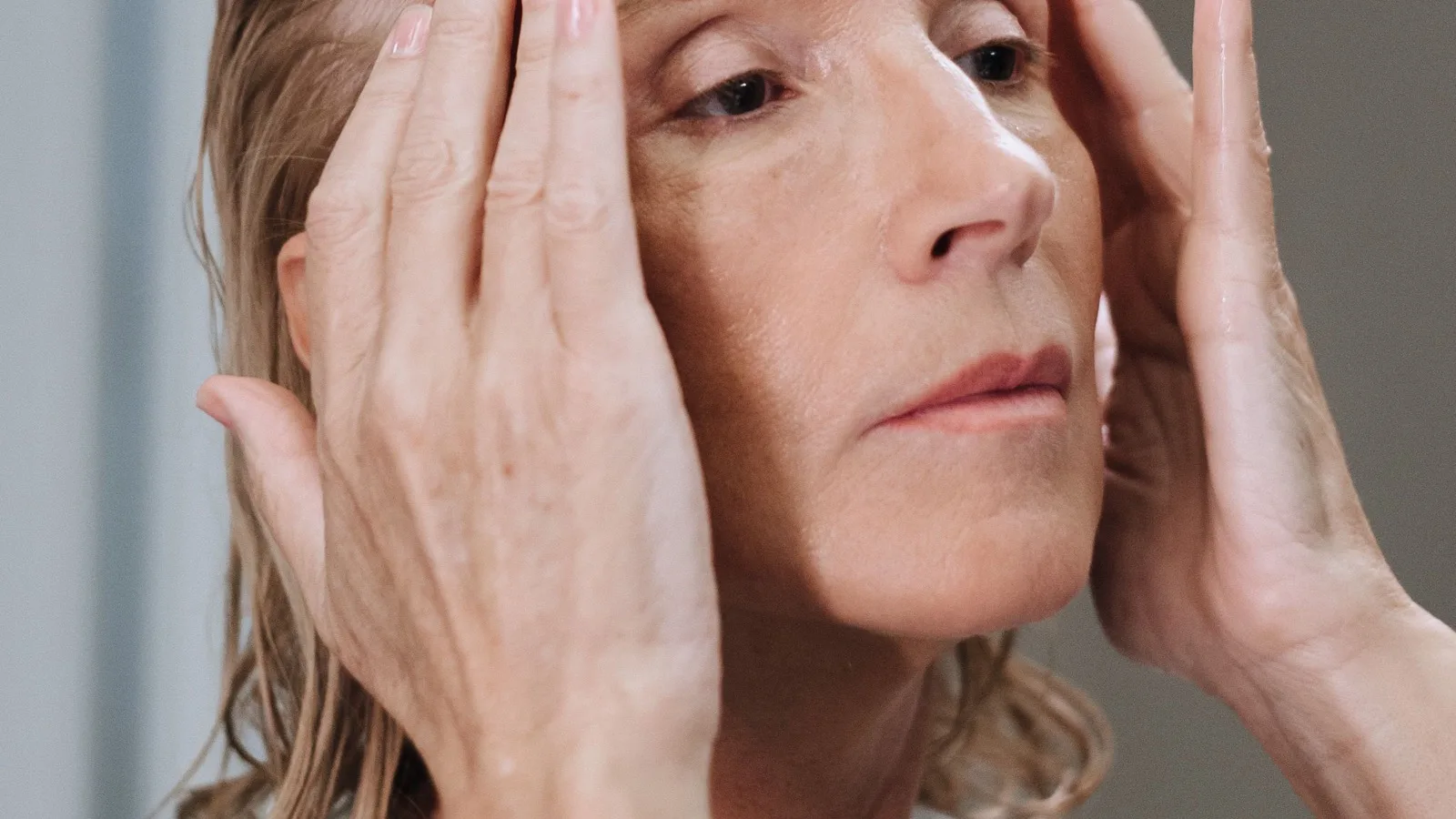 A woman practicing a gentle face massage as part of a skincare routine.