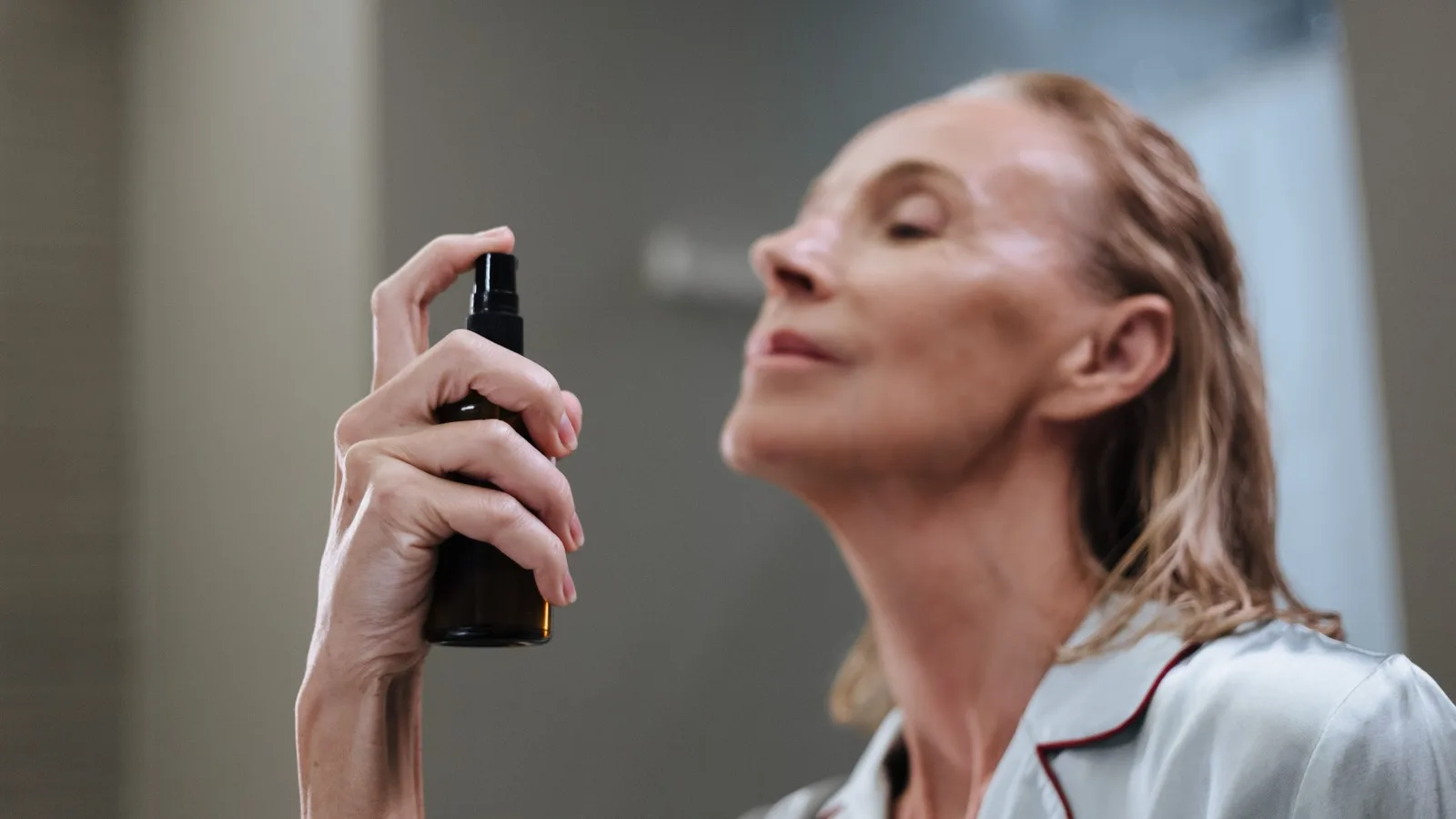A senior woman applying skincare as part of her morning routine.