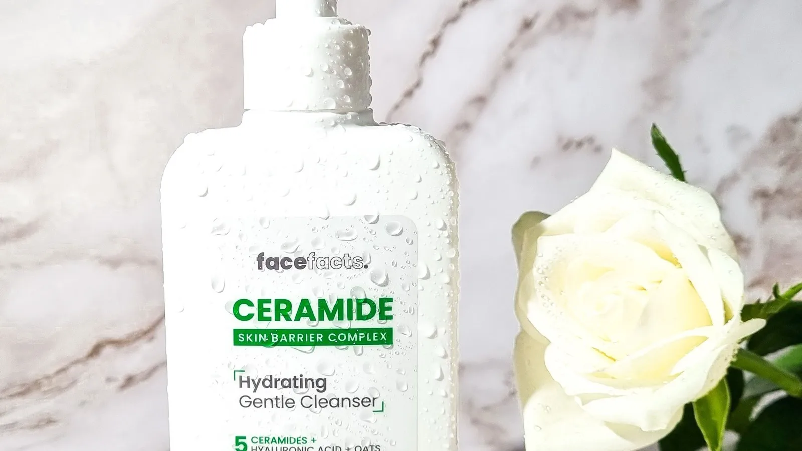 A gentle cleanser arranged with a fresh rose for a sensitive-skin routine.