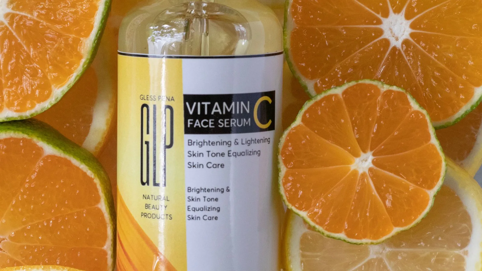 Vitamin C serum arranged with fresh citrus for ingredient context.