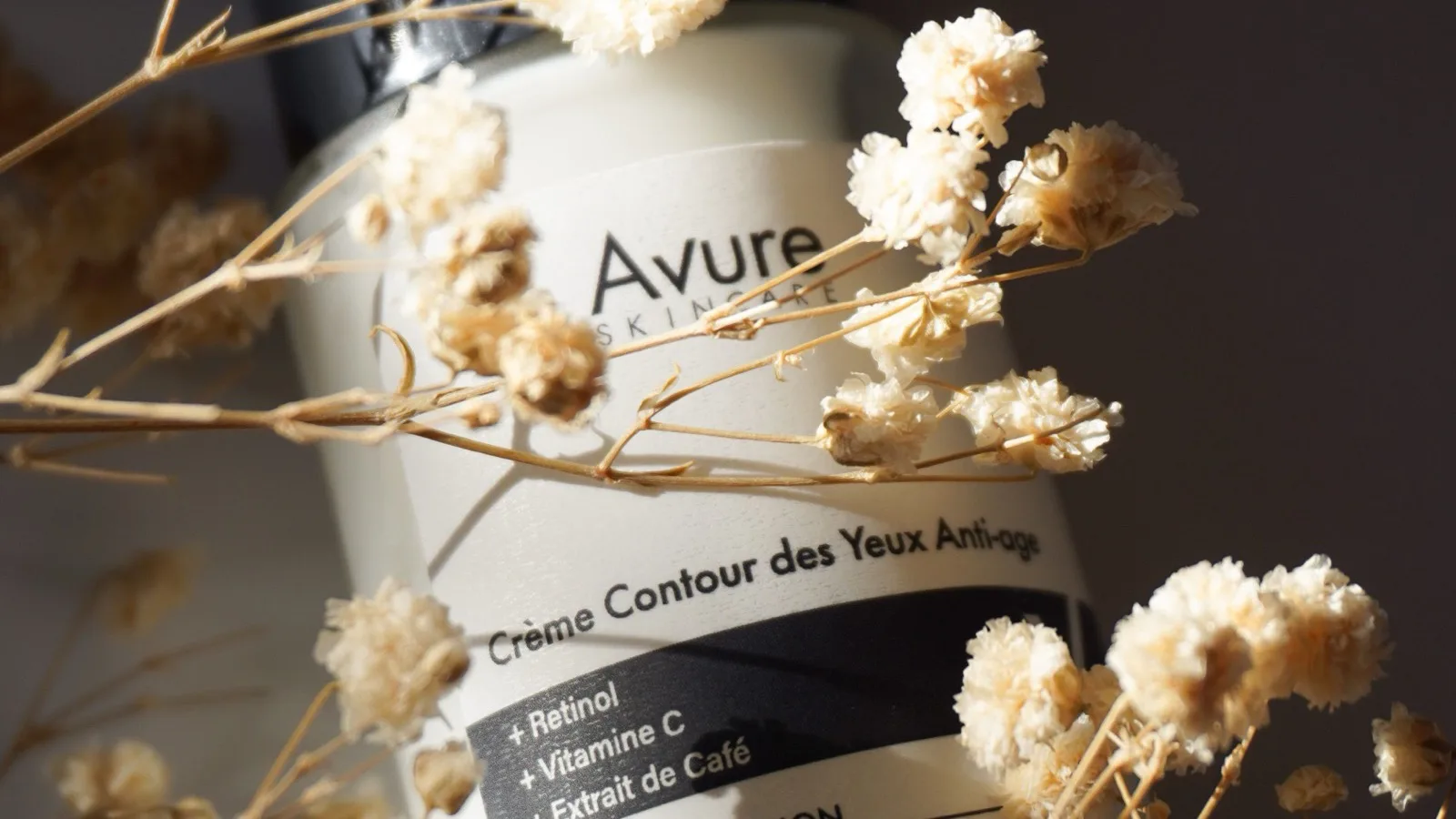A skincare product arranged with soft natural decoration.