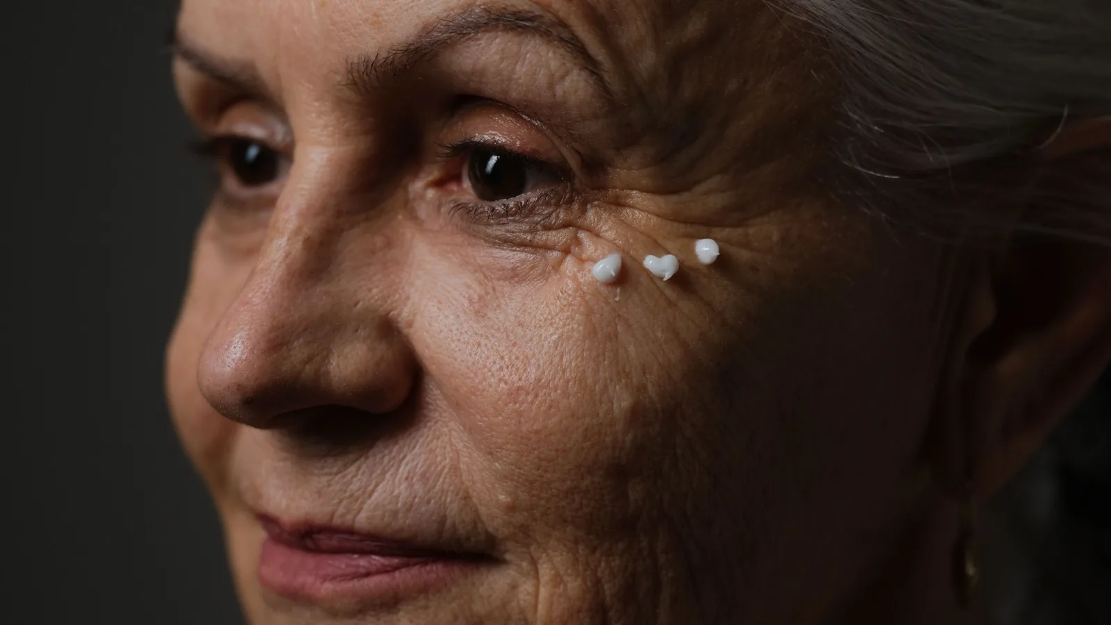 A mature woman following a calm skincare routine.