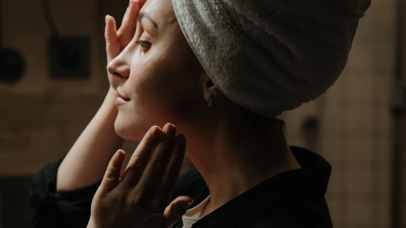 A woman enjoying a soothing skincare routine at home.