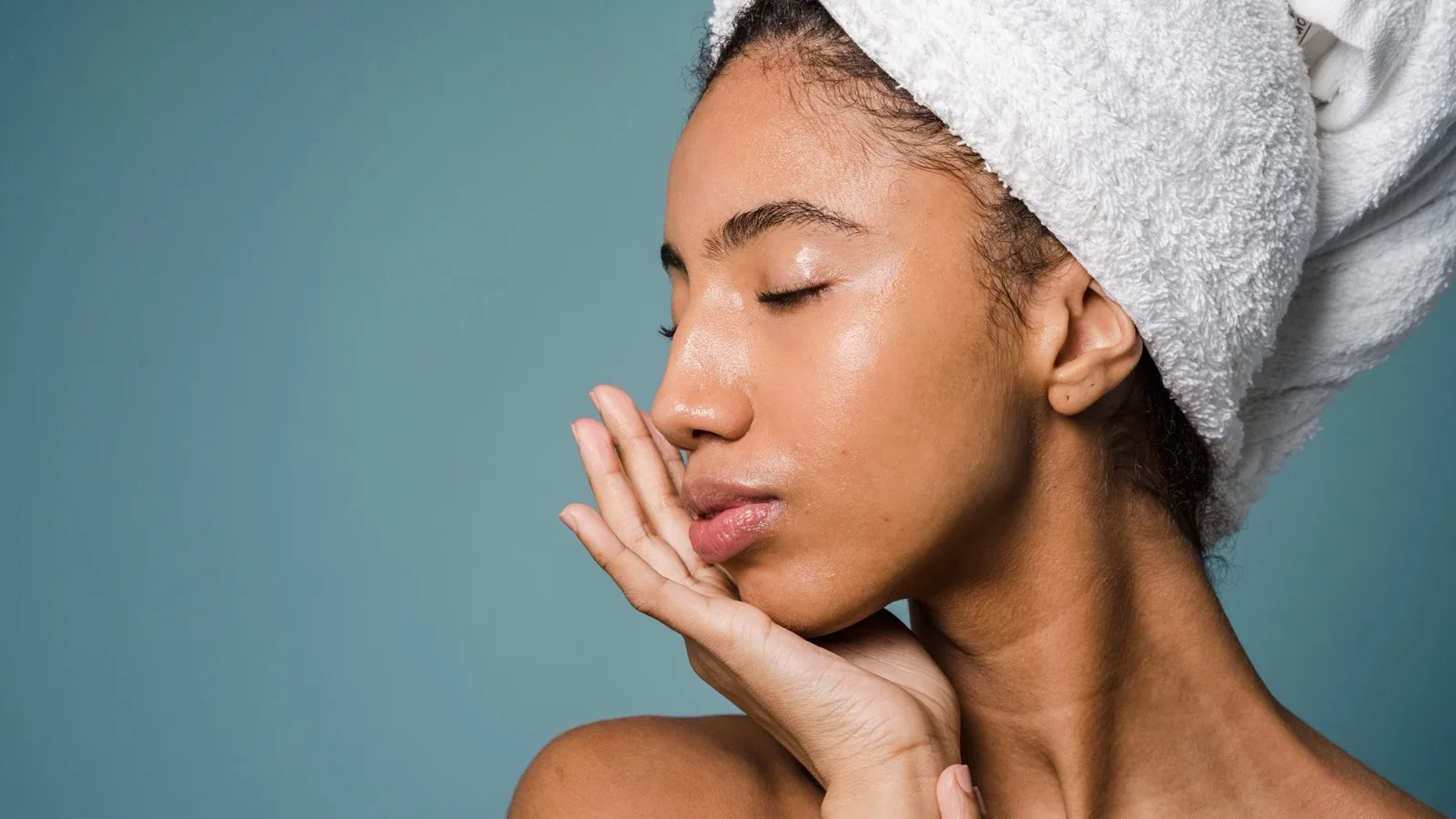 A woman touching her face during a calm skincare routine.