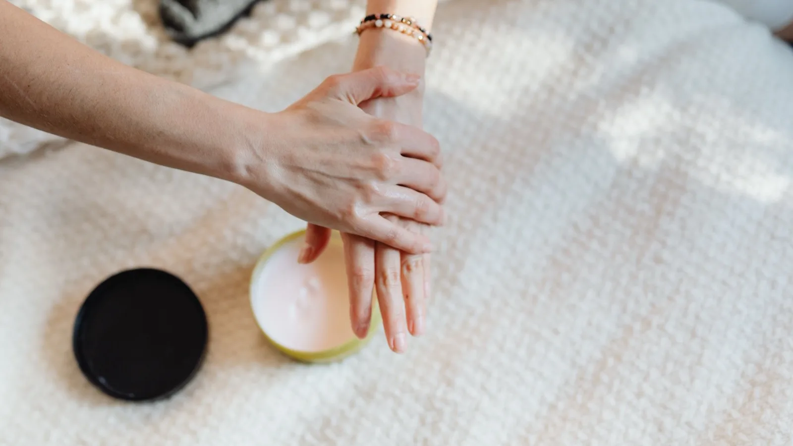 A person applying moisturizer as part of a daily skincare routine.
