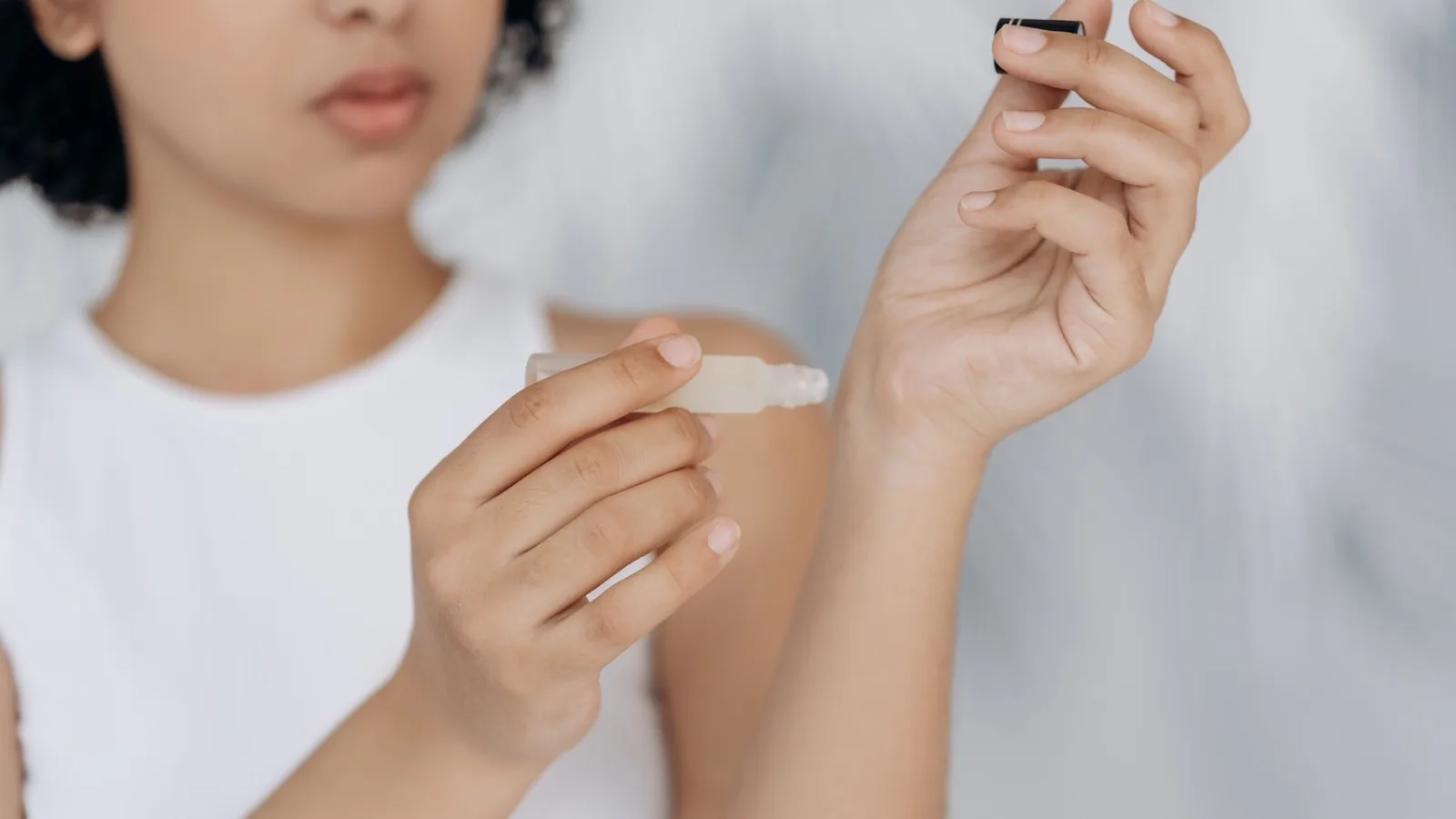 A person applying skincare product to a small area of the wrist.