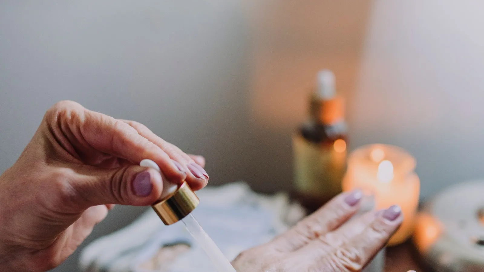 A person applying skincare serum with a dropper.