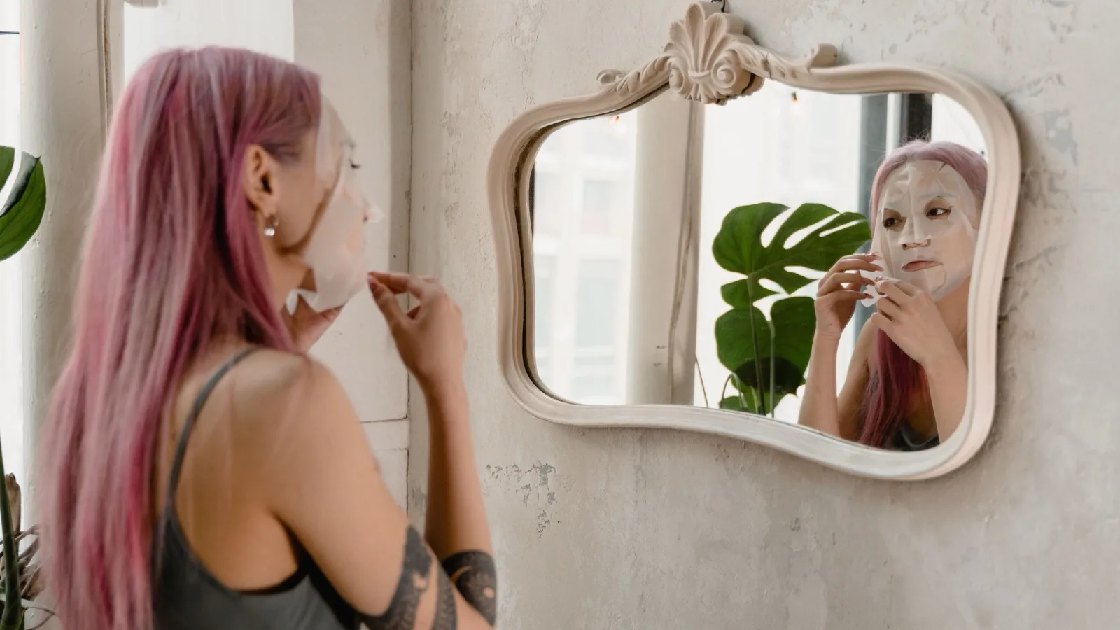 Woman applying a facial mask as part of a targeted skincare routine.