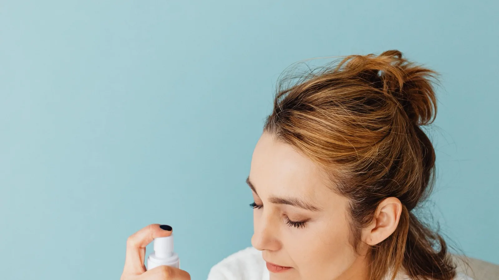 A woman using facial spray during a calm skincare routine.