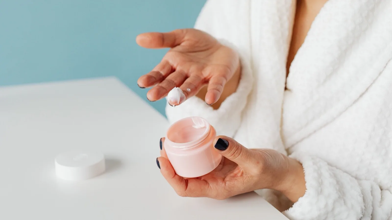 A person applying moisturizer as part of a simple skincare routine.
