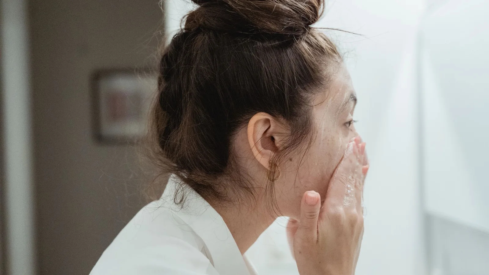 A woman washing her face as part of an evening skincare routine.