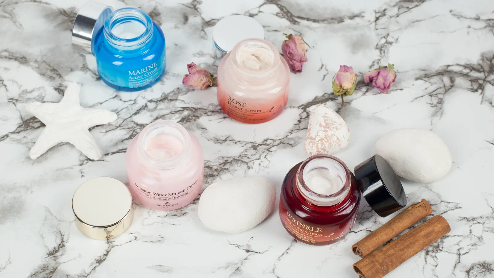 Skincare creams arranged on a marble surface.