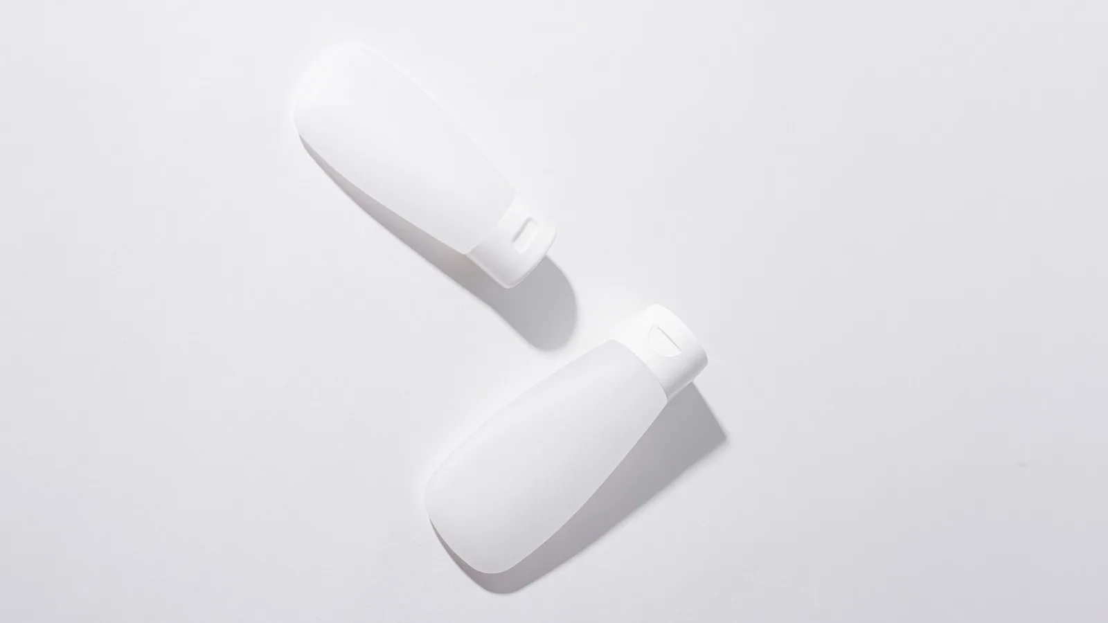 Unlabeled skincare containers arranged in a neutral still life.