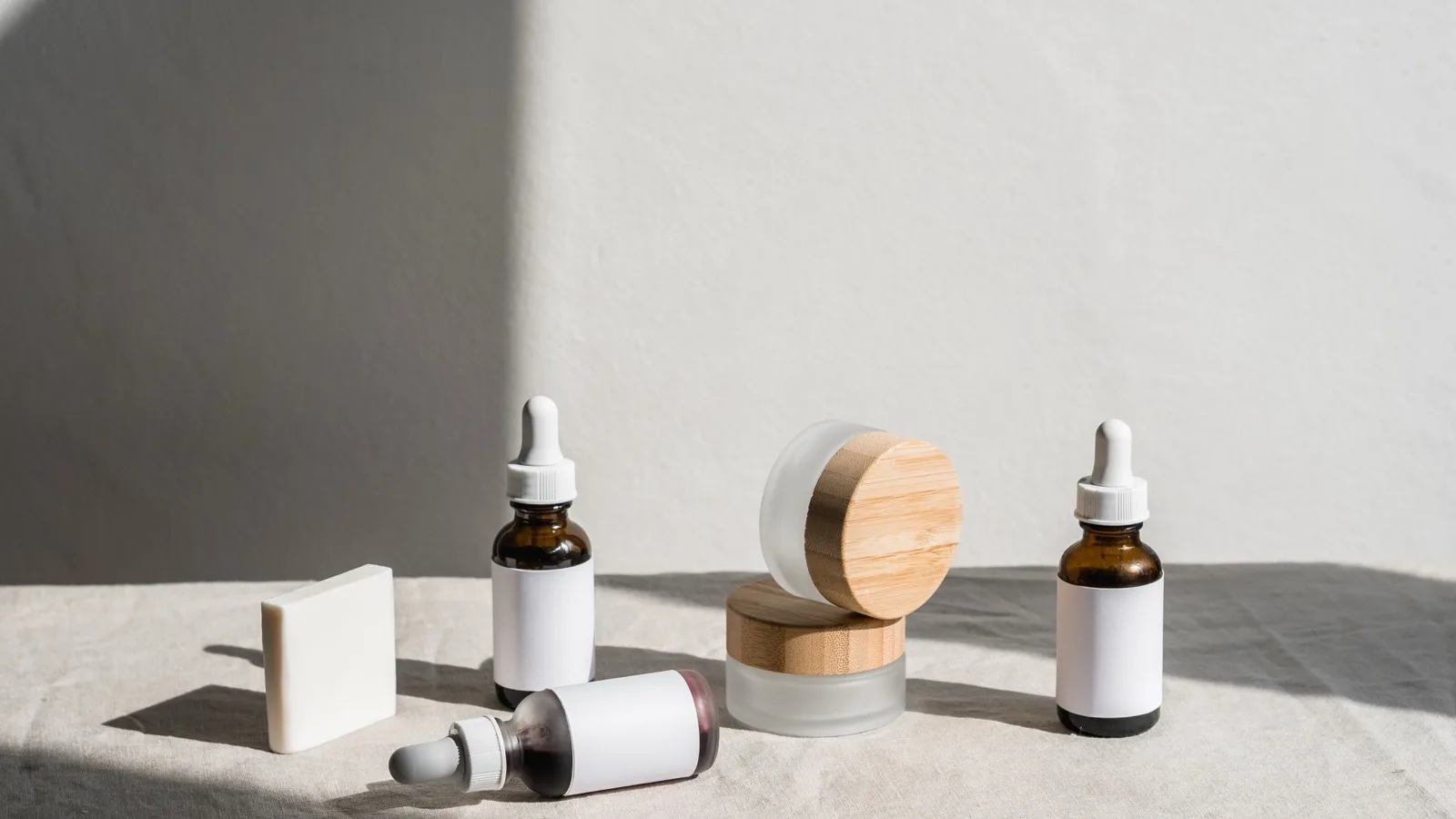 Skincare jars and dropper bottles arranged in a simple comparison.