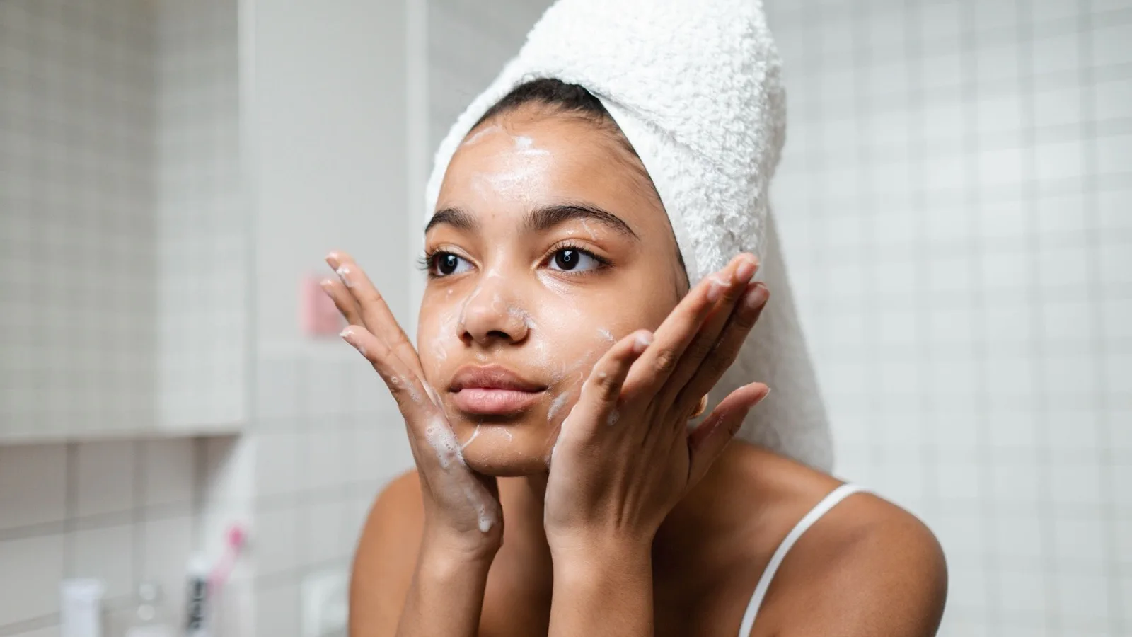 A person gently washing their face as part of a sensitive-skin routine.