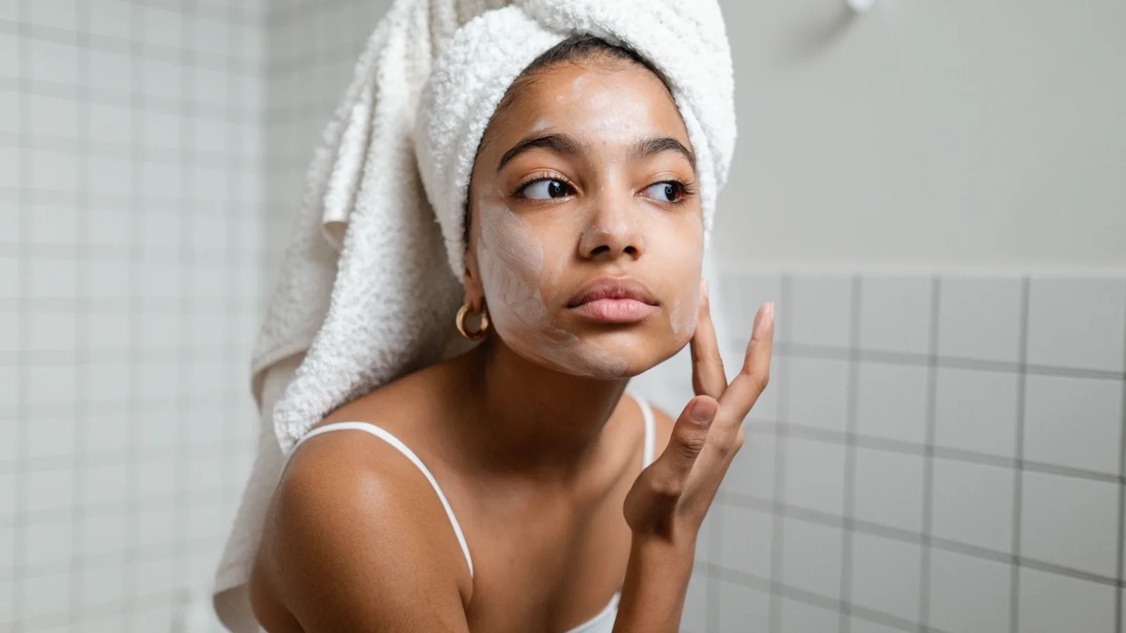 A woman washing her face as part of a gentle skincare routine.