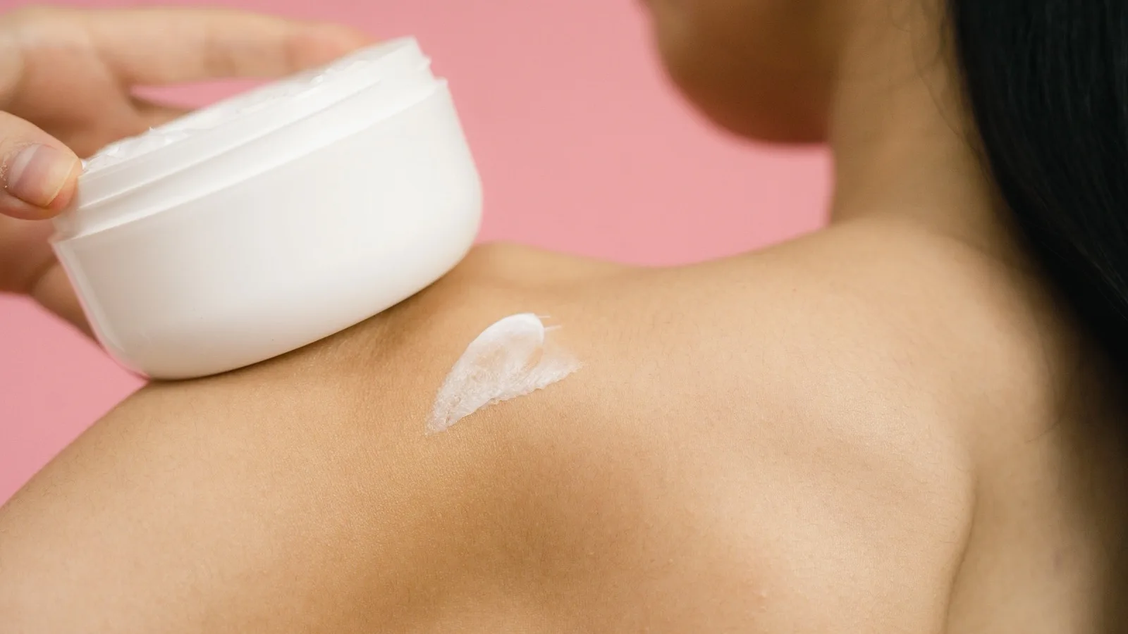 A woman applying moisturizer as part of a simple skincare routine.