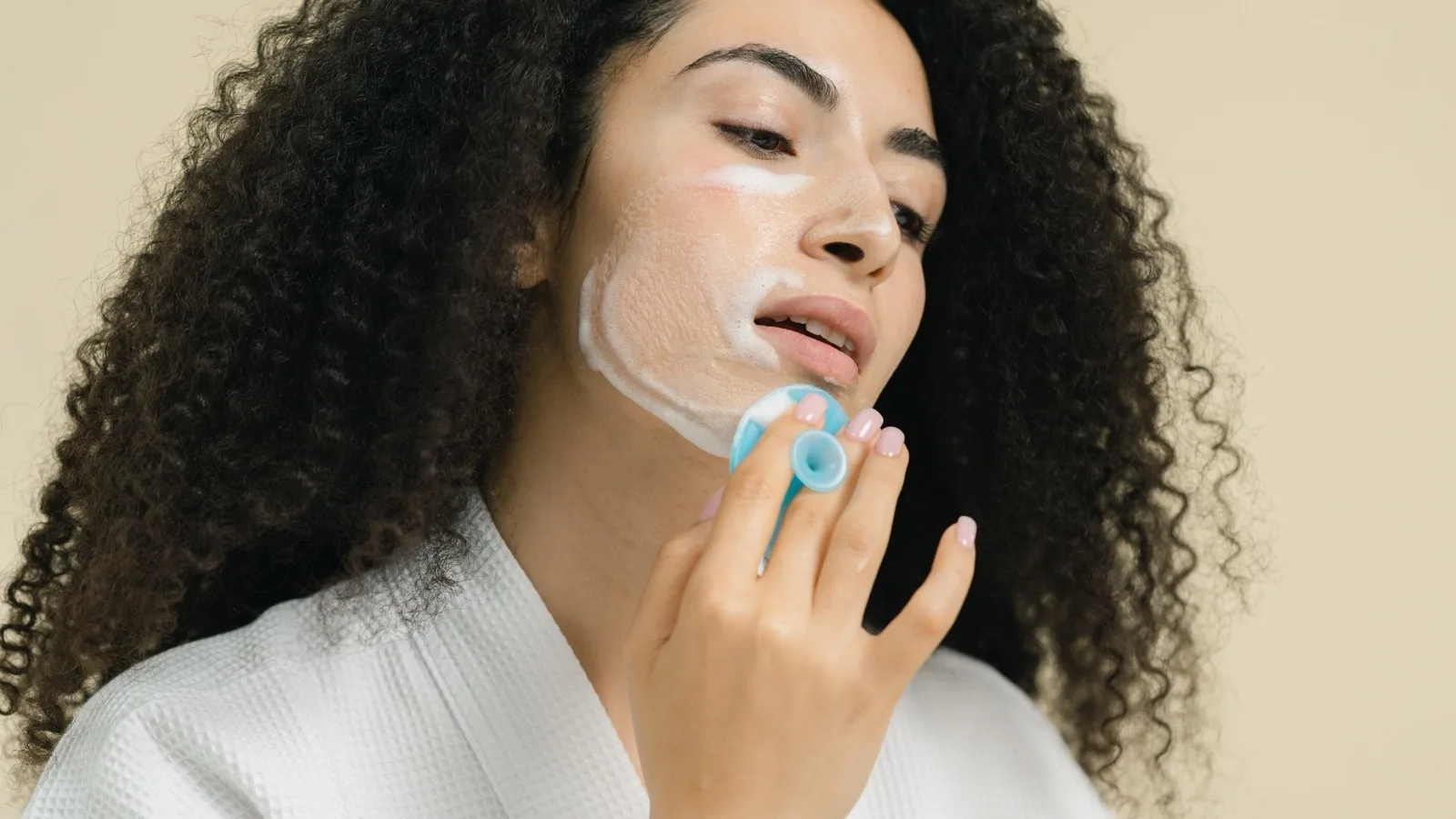 A person using a facial cleansing tool as part of a skincare routine.